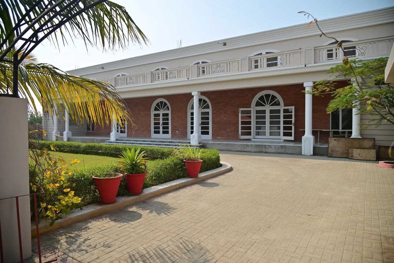 Colonnaded resort building with arched doors opening onto a paved courtyard
