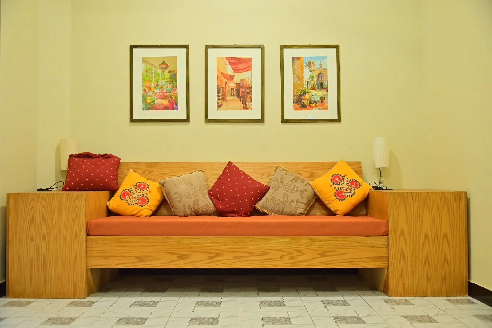 Warm seating alcove with cushions and framed paintings inside a suite at the resort